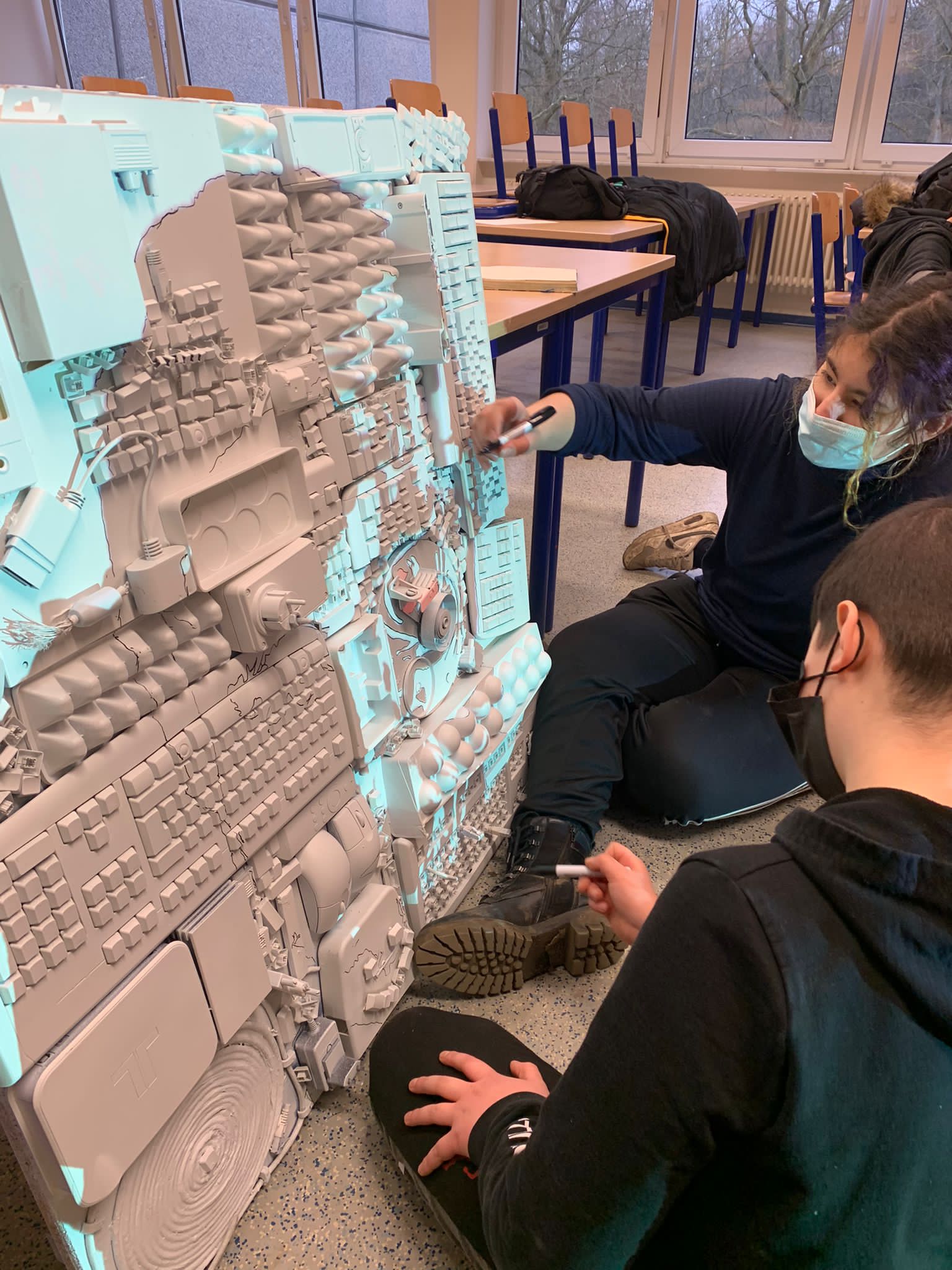 Zwei Schüler untersuchen ein großes dreidimensionales Architekturmodell einer Stadt im Klassenzimmer.