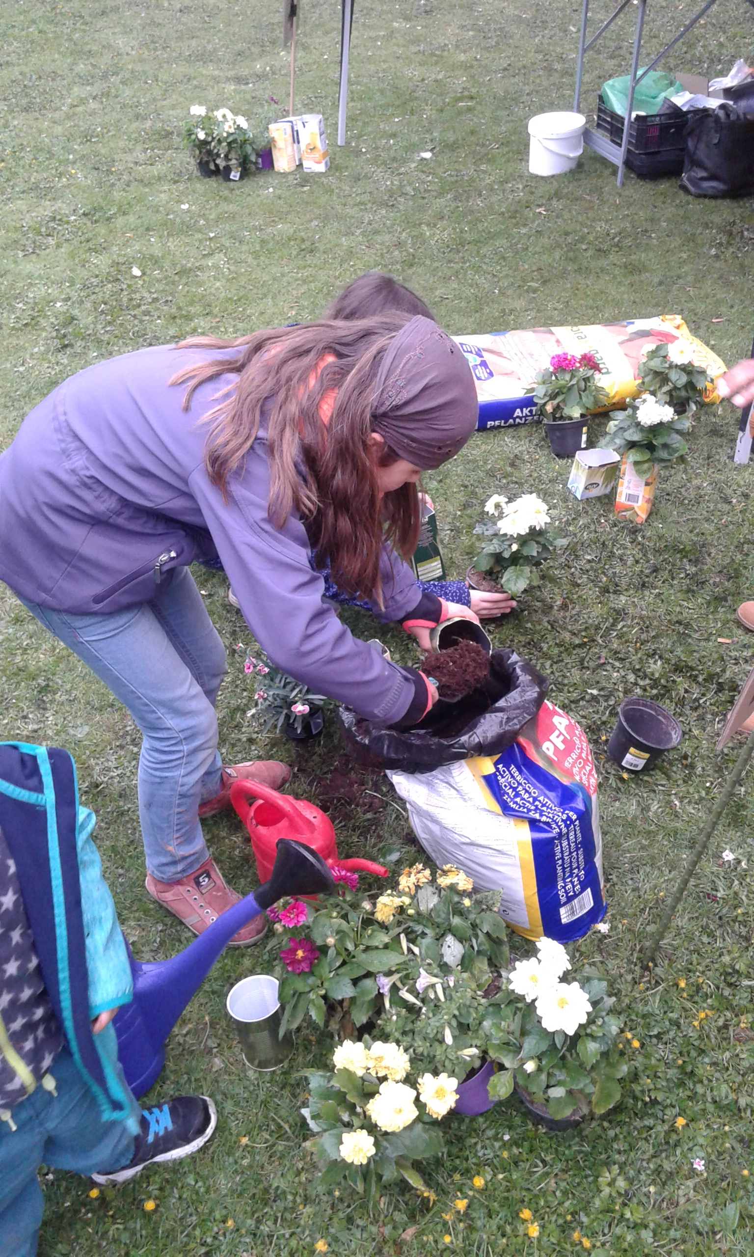 Eine Frau pflanzt Blumen in einem Gemeinschaftsgarten ein.