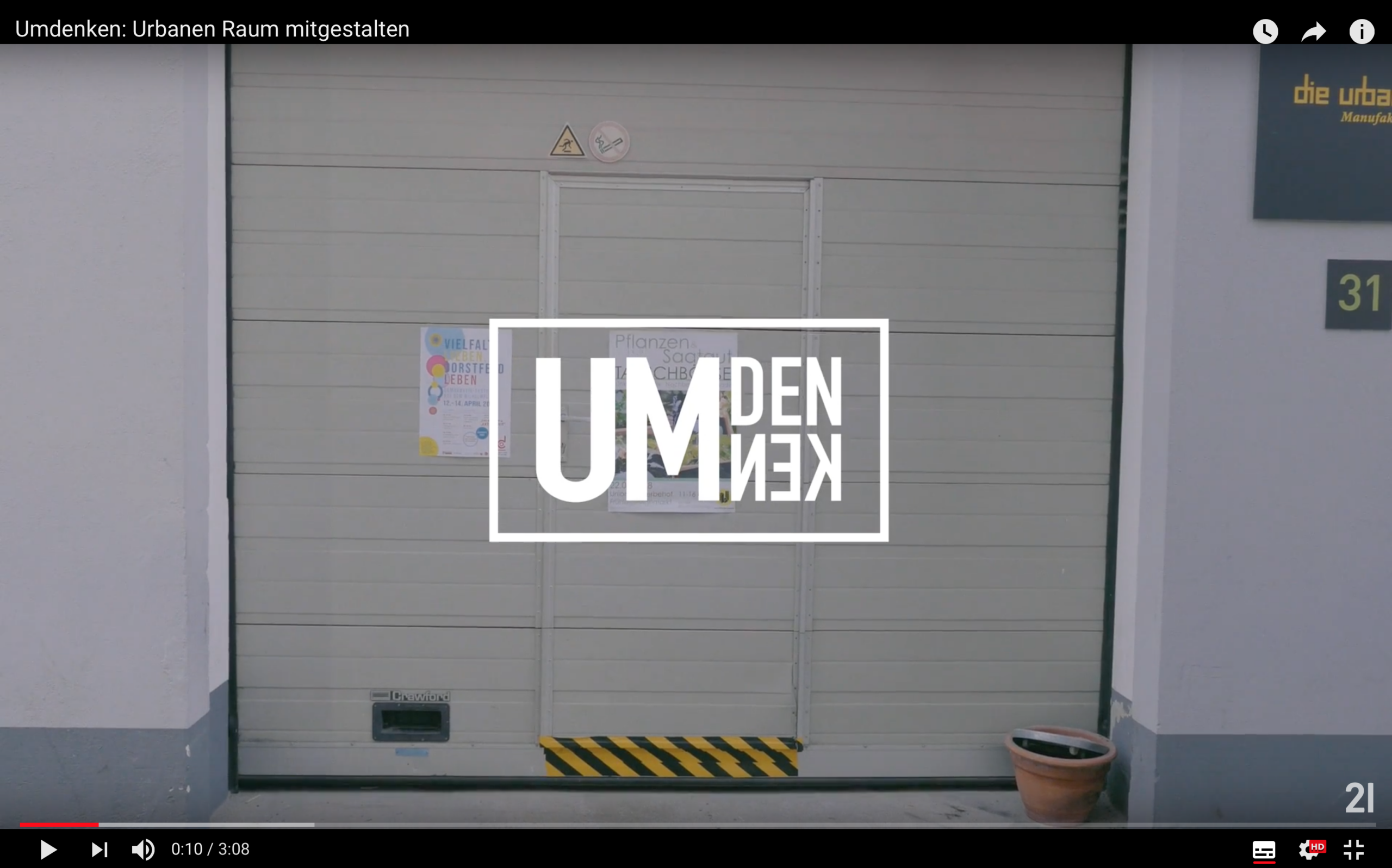 Geschlossene Garagentor mit Plakaten und dem überlagerten Logo Umdenken.