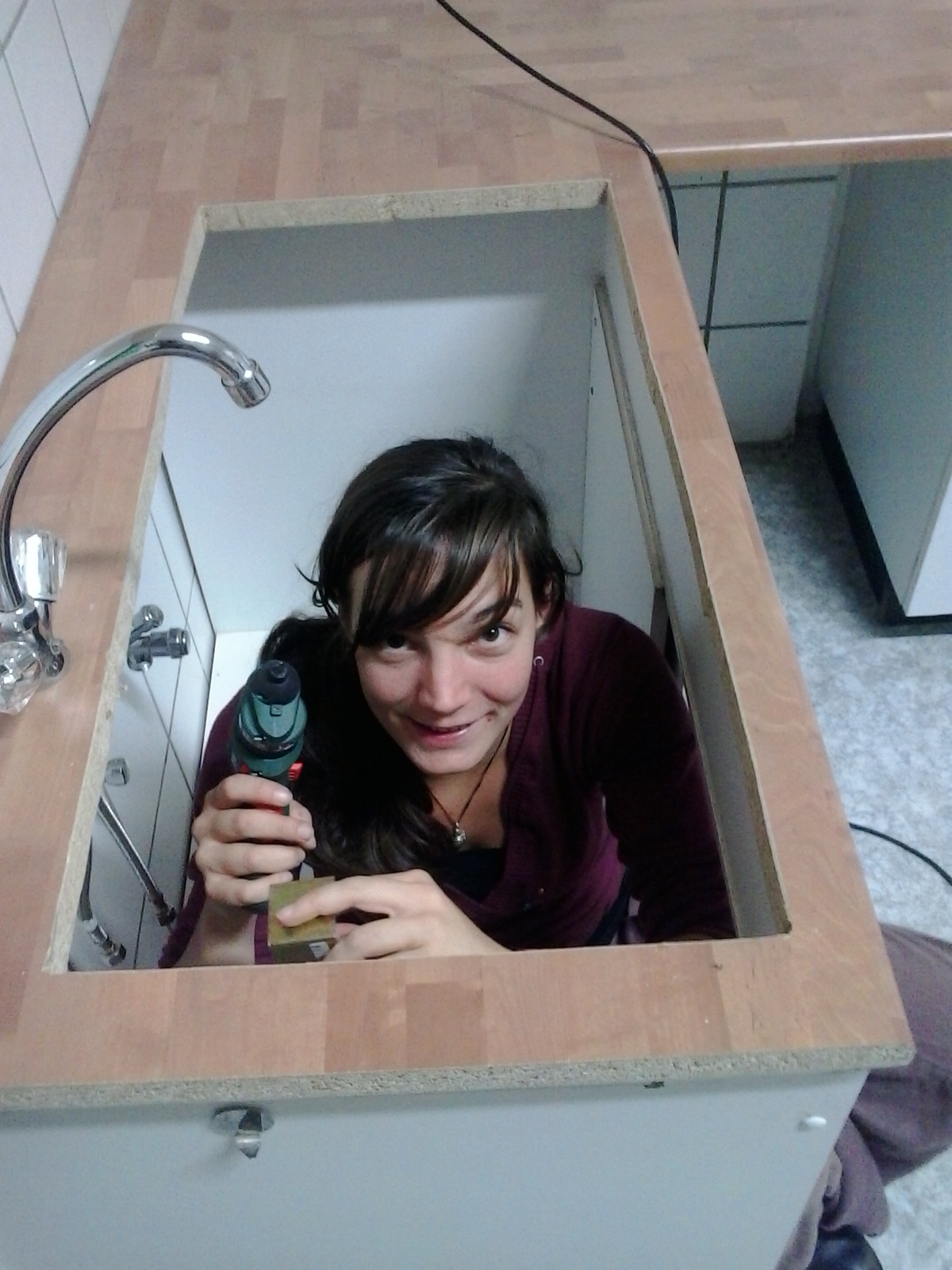 Frau sitzt in einer Badewanne und hält ein Messinstrument in der Hand.