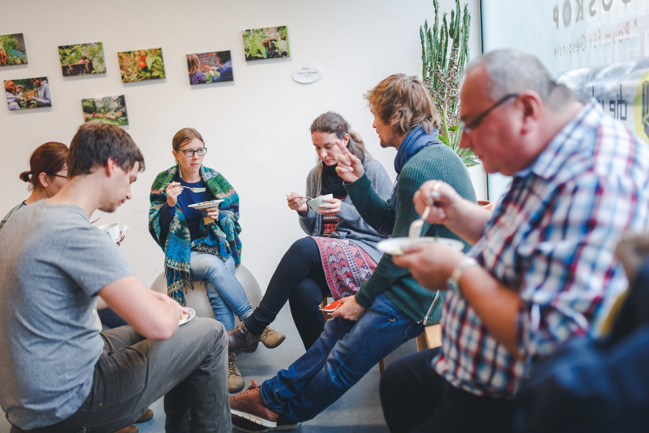 Eine Gruppe von Menschen sitzt in einem Kreis und isst gemeinsam.