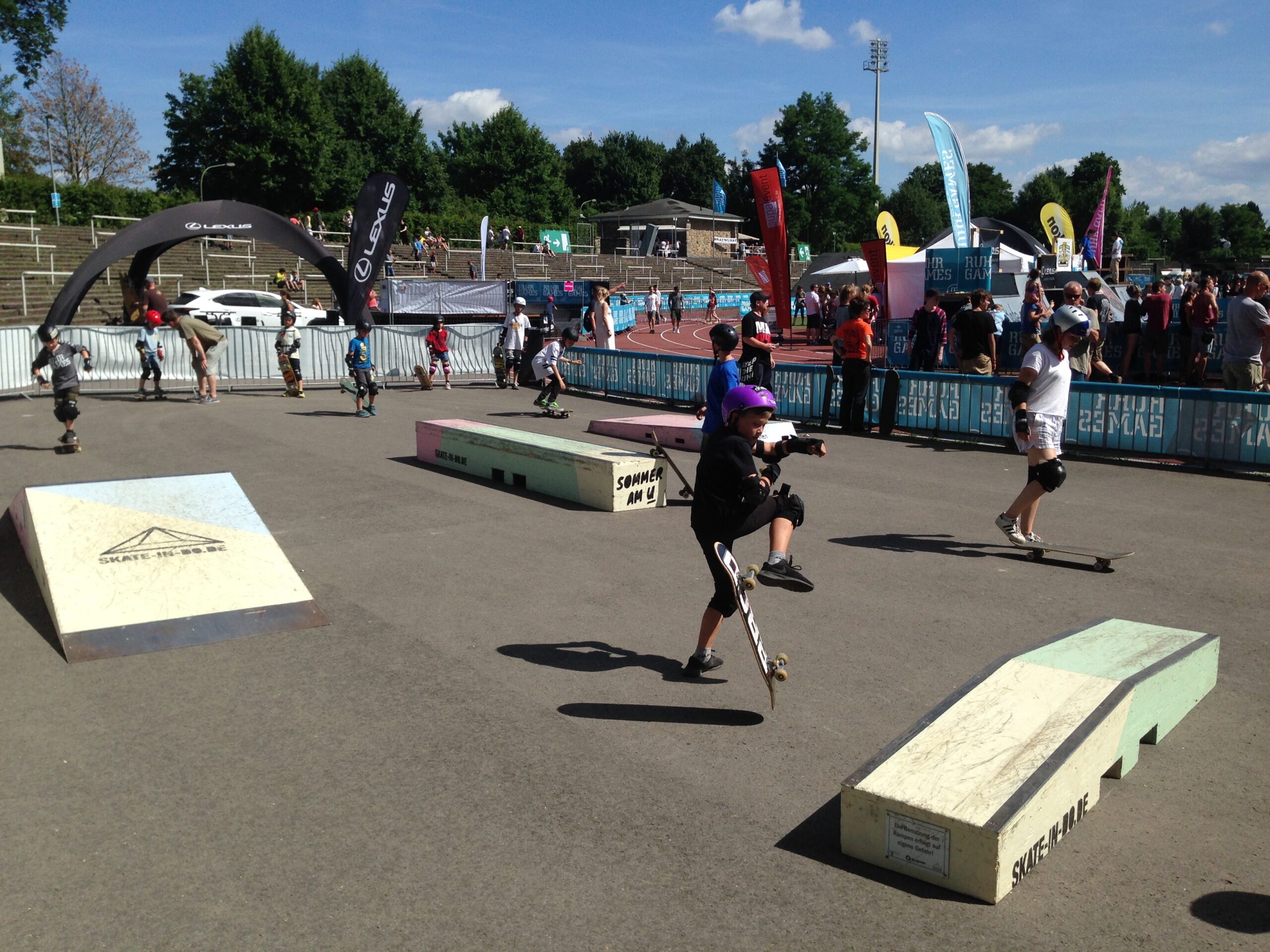 Skateboardfahrer nutzen eine öffentliche Skateanlage mit Rampen und Hindernissen.