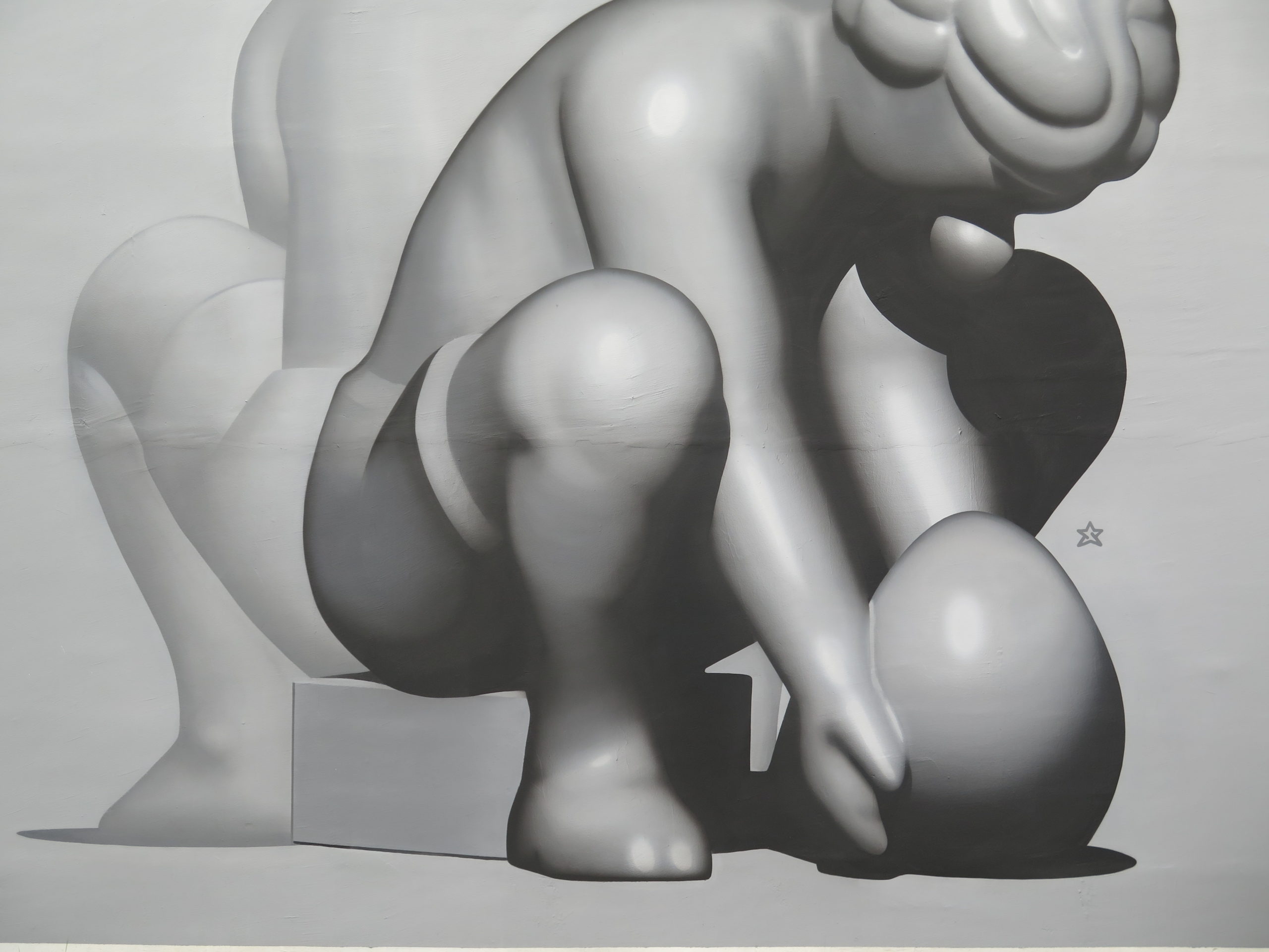 Weiße Skulptur einer sitzenden Figur mit abstrakten, organischen Formen und Volumen.