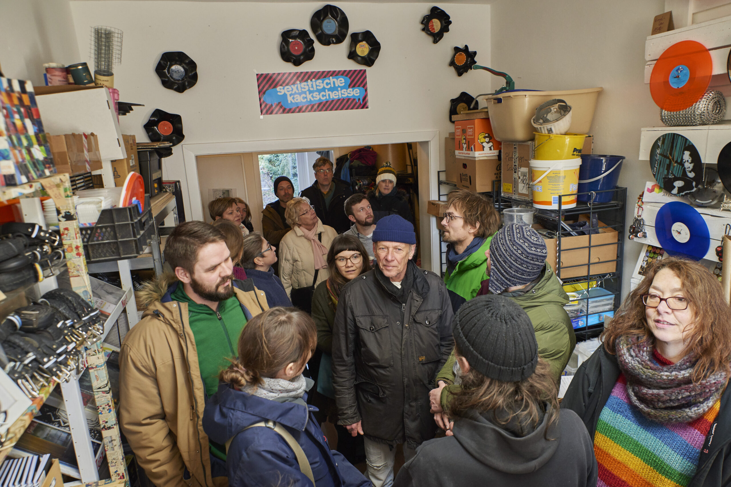 Eine Gruppe von etwa 20 Personen besichtigt einen Raum voller Schallplatten und Musik-Memorabilien.