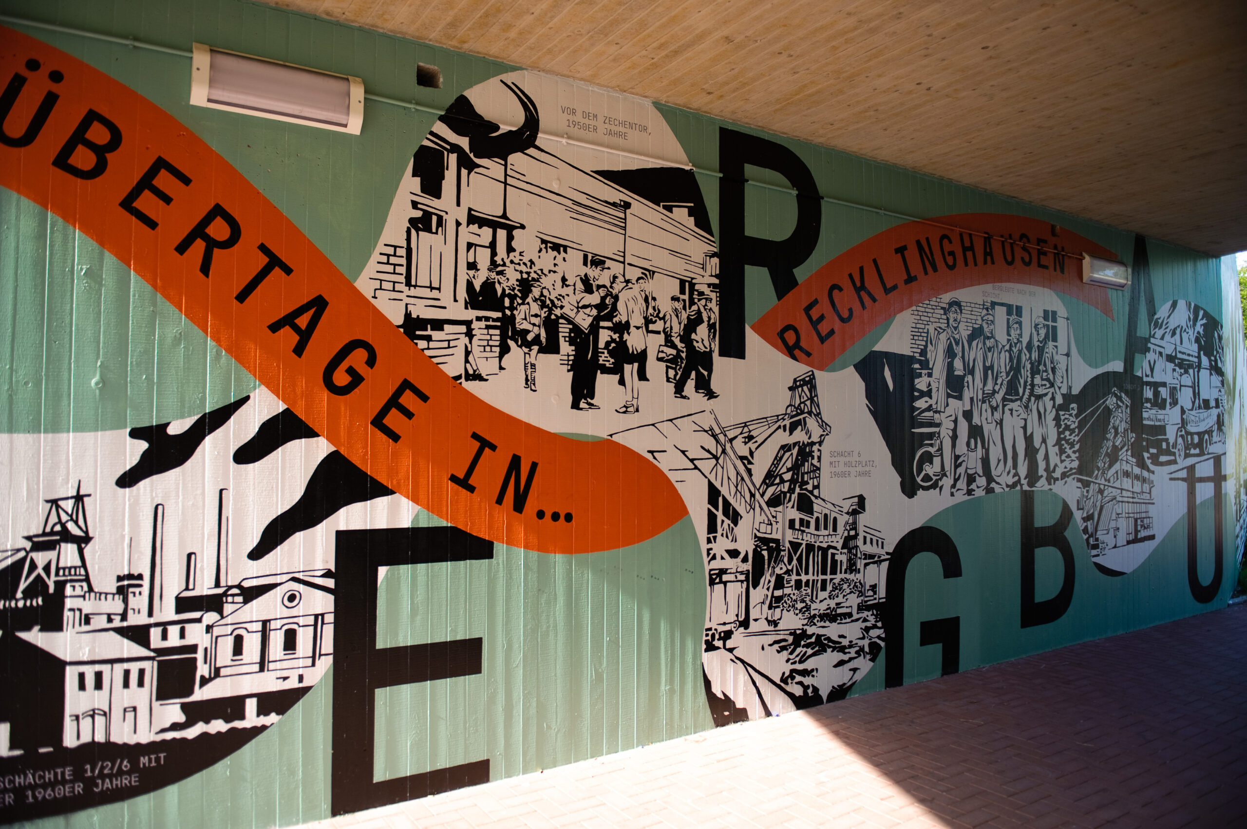 Wandmalerei in Grün und Orange mit historischen Illustrationen und Text Übergage in Recklinghausen.