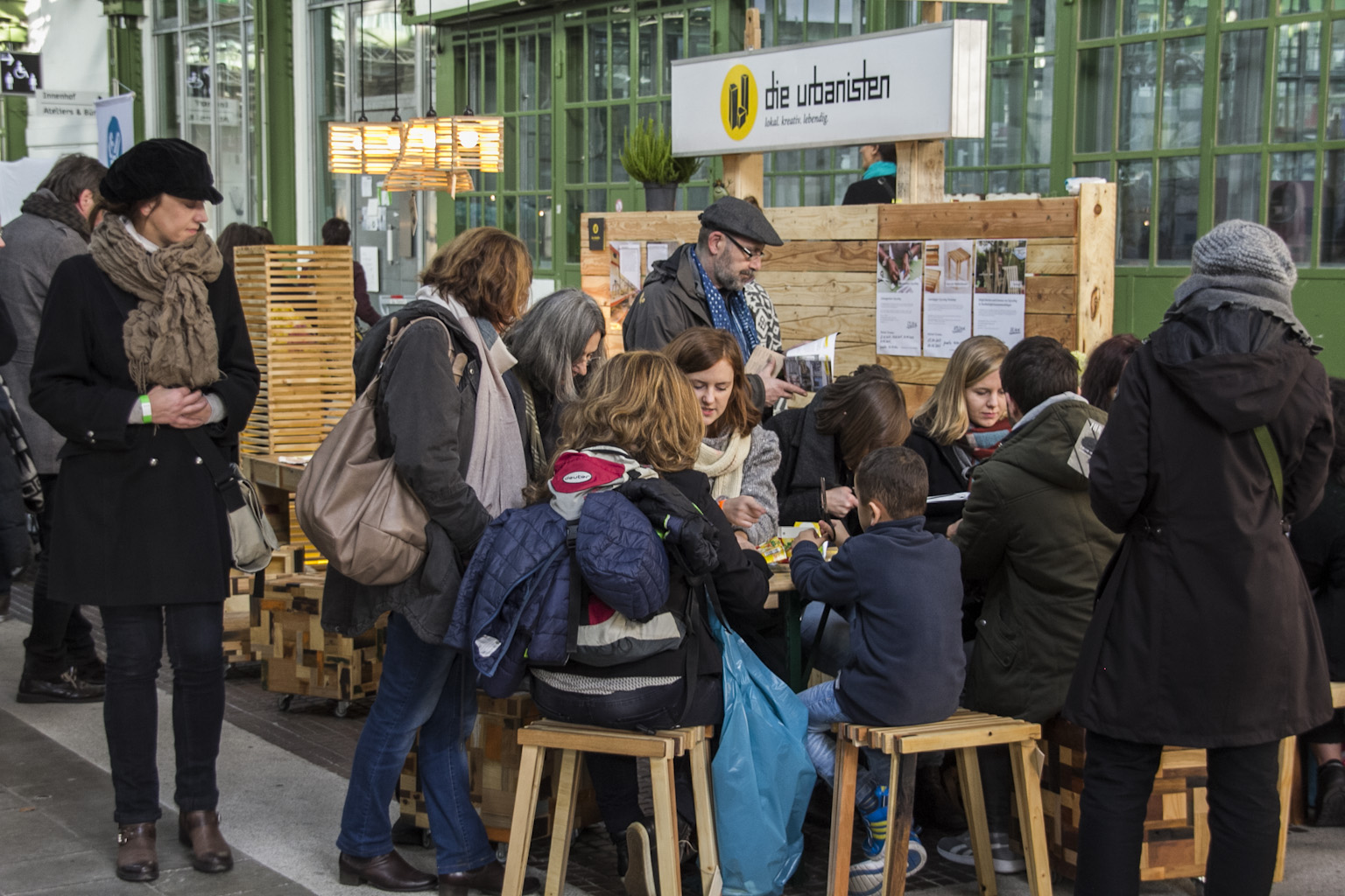 Gruppe von Erwachsenen und Kindern beteiligt sich an einer Informationsveranstaltung zu Stadtentwicklung.