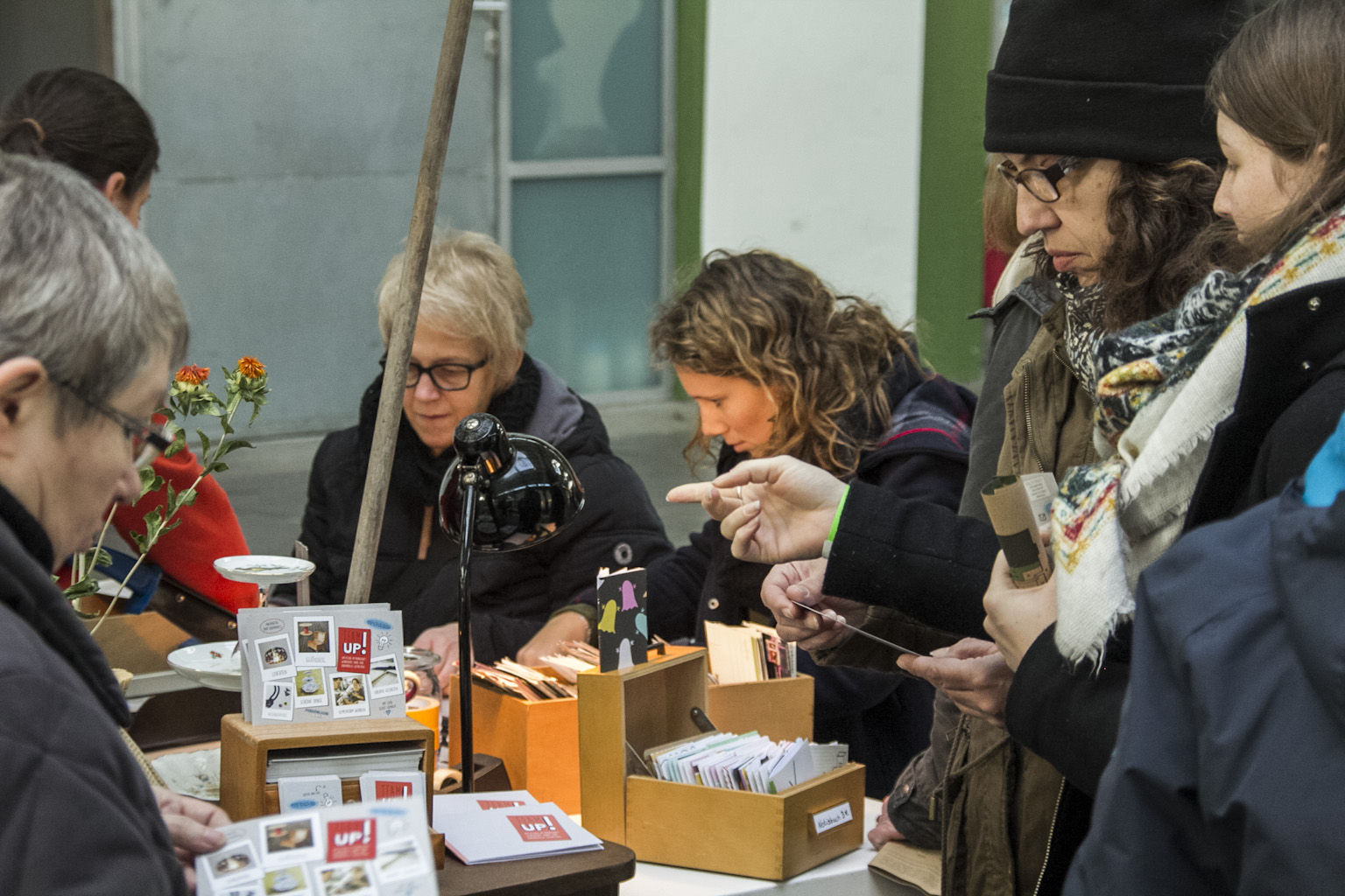 Eine Gruppe von Menschen steht an einem Tisch mit Informationsmaterialien und Blumen.